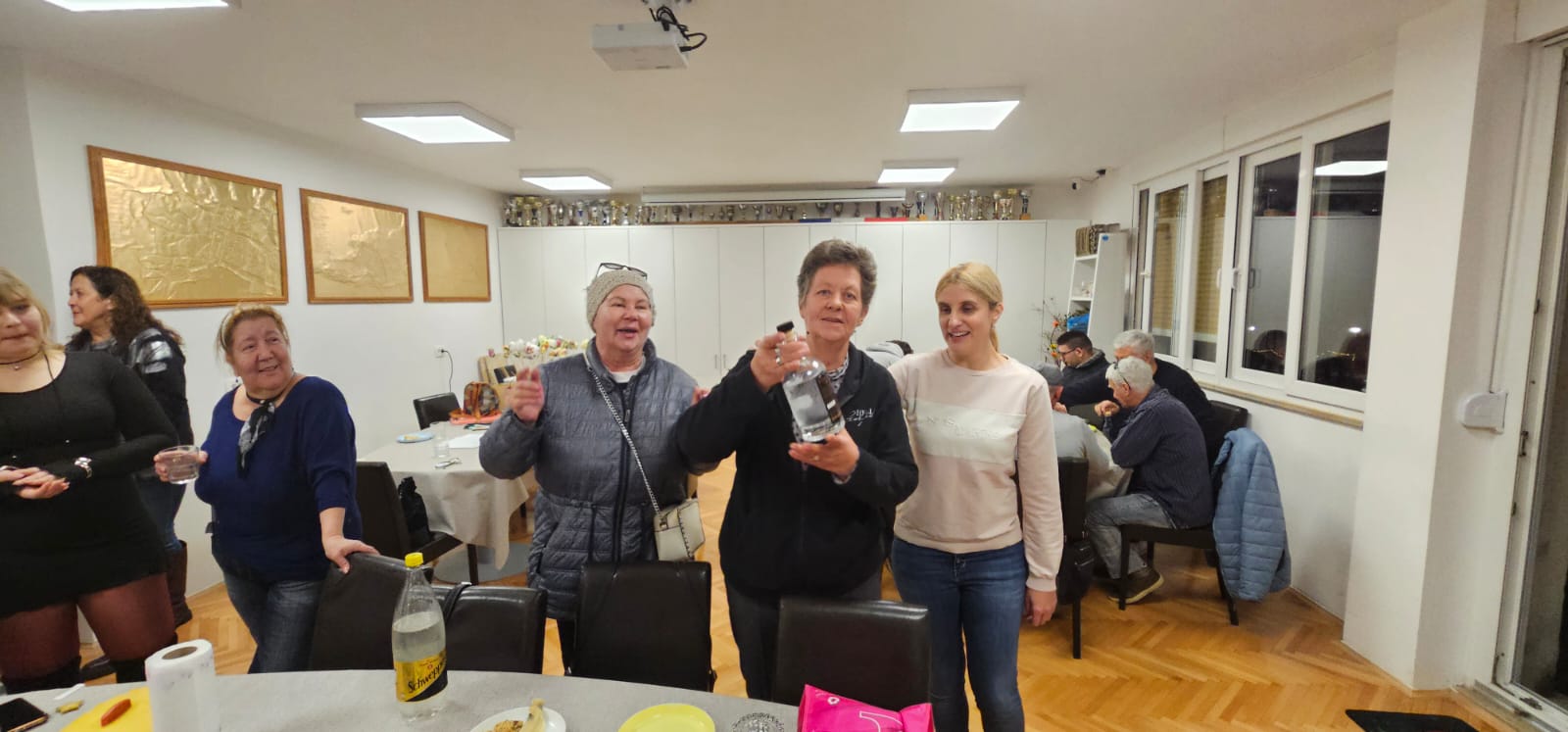 Proslava Vesninog rođendana u udruzi. Vesna, Ivana i Dijana poziraju u sali.